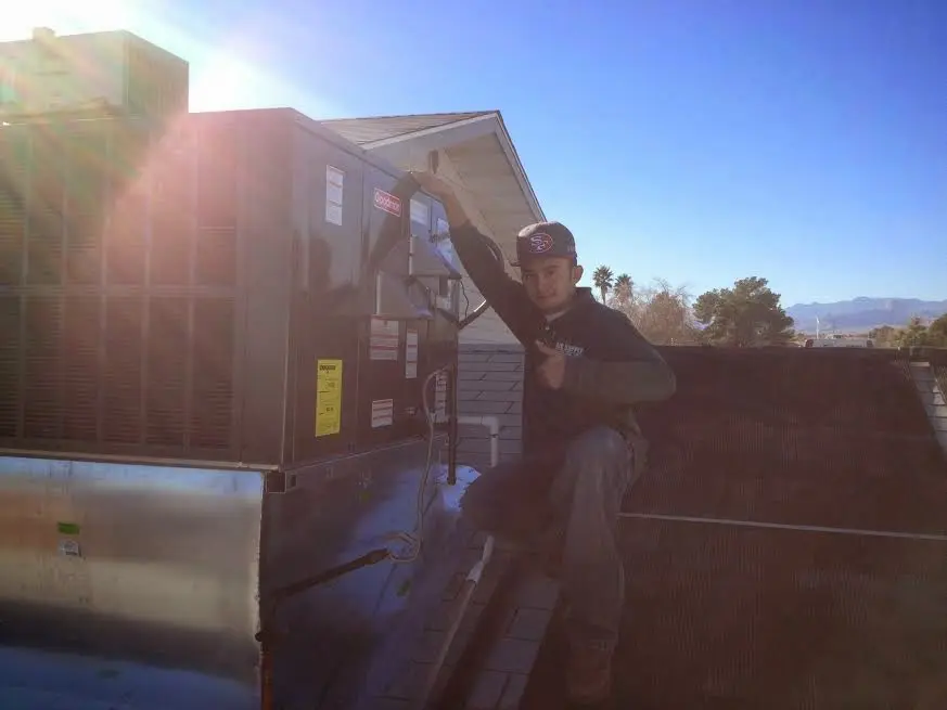 HVAC technician performing HVAC Inspection on a rooftop unit in Addison